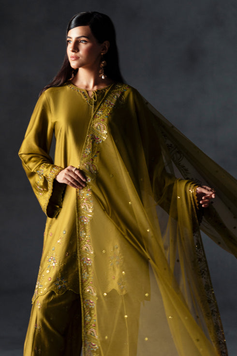 Woman wearing a traditional yellow outfit with a dark background